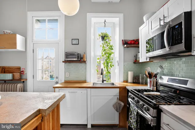 a kitchen with stainless steel appliances granite countertop a stove a microwave and a refrigerator