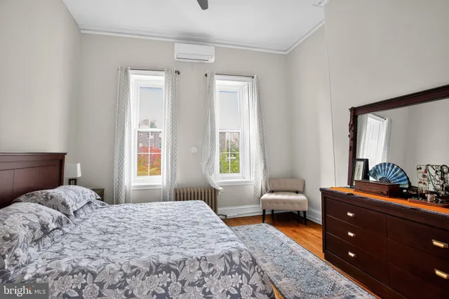 a bedroom with a bed and a dresser next to a window