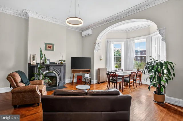 a living room with furniture a potted plant and a flat screen tv