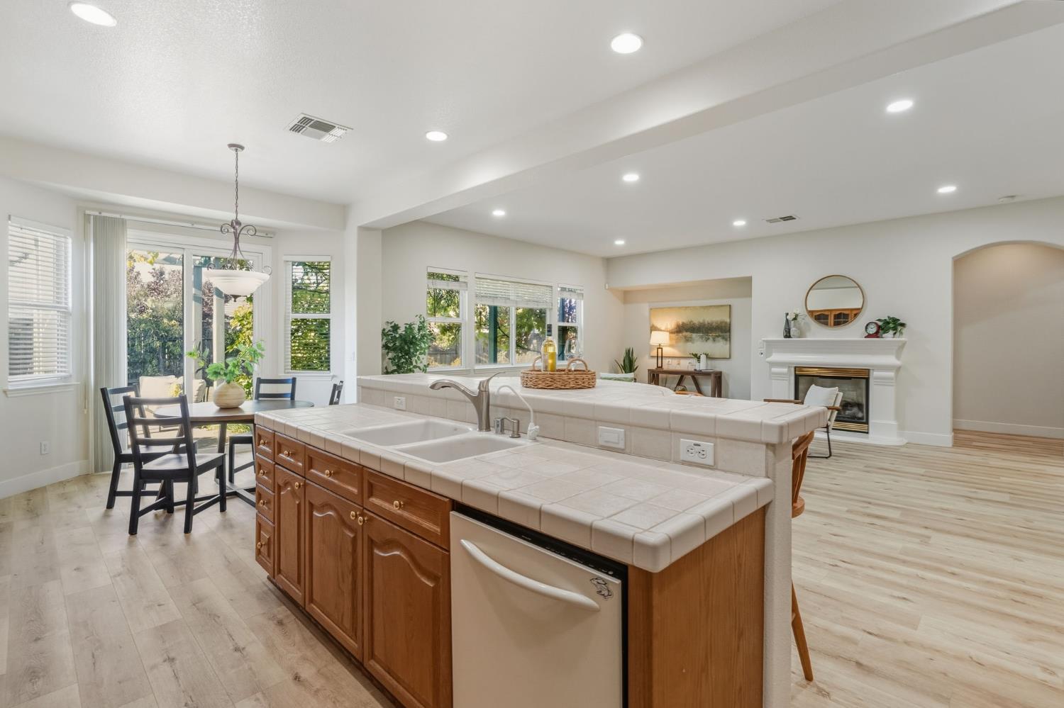 3412 Muscat Way Rancho Cordova, CA 95670 - Photo 15 of 33 a dining hall with stainless steel appliances granite countertop a kitchen island a stove a sink a dining table and chairs with wooden floor