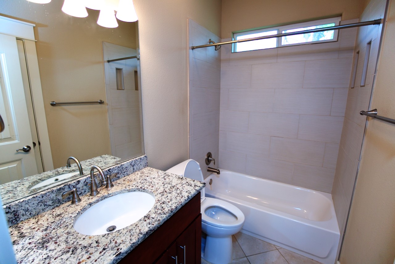 1800 Richcreek Road, Unit B Austin, TX 78757 - Photo 8 of 10 a bathroom with a granite countertop sink toilet and shower
