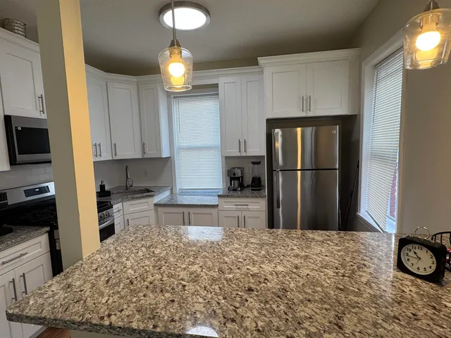 a kitchen with a refrigerator and a stove top oven