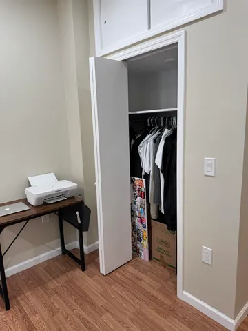 a view of walk in closet with clothes and shoes