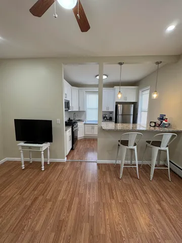 a living room with furniture a wooden floor and a flat screen tv