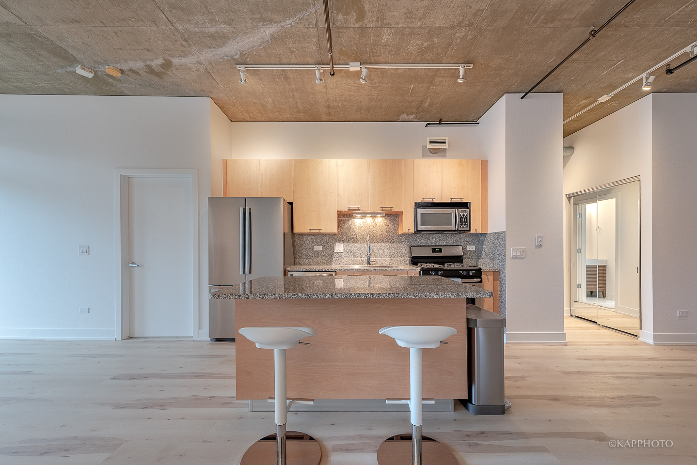 111 South Morgan Street, Unit 619 Chicago, IL 60607 - Photo 16 of 35 a kitchen with stainless steel appliances kitchen island granite countertop a refrigerator and microwave