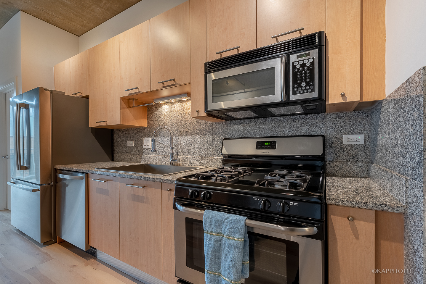 111 South Morgan Street, Unit 619 Chicago, IL 60607 - Photo 17 of 35 a kitchen with stainless steel appliances granite countertop a stove microwave and sink