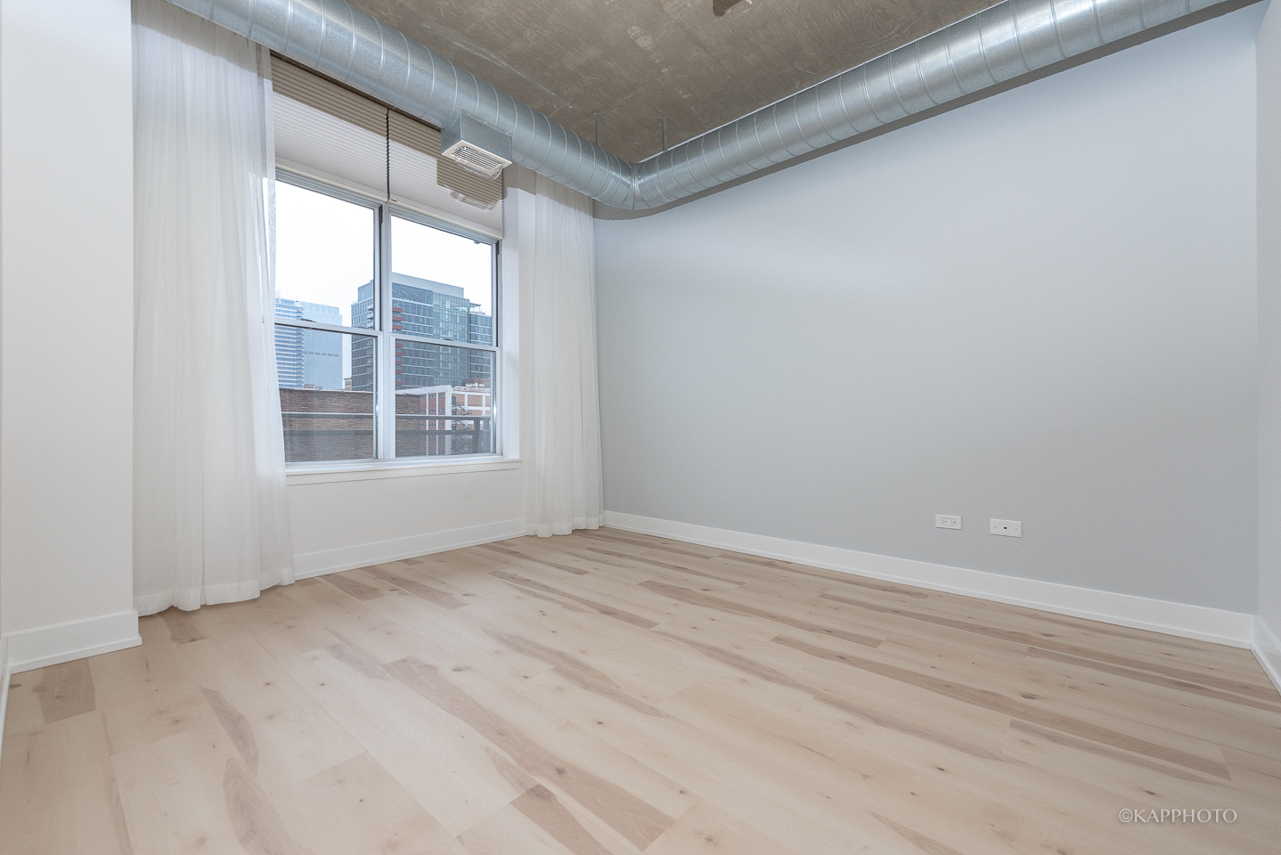 111 South Morgan Street, Unit 619 Chicago, IL 60607 - Photo 24 of 35 an empty room with wooden floor and windows