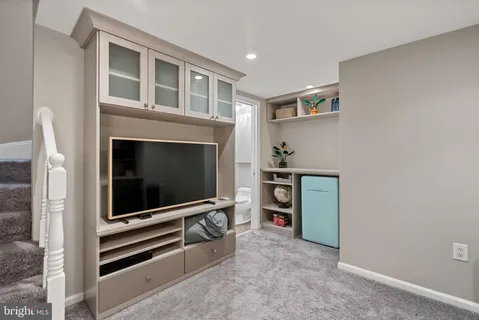 a living room with stainless steel appliances white walls and a fireplace