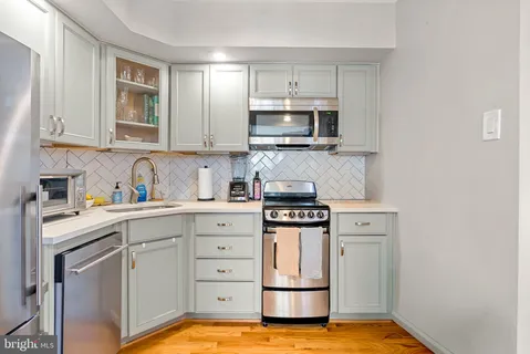 a kitchen with stainless steel appliances granite countertop a sink stove and cabinets