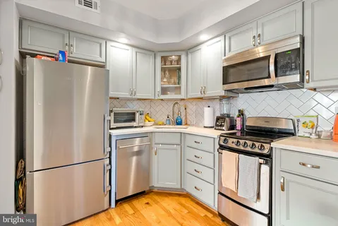 a kitchen with white cabinets and stainless steel appliances