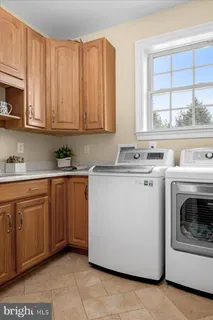 a utility room with stainless steel appliances granite countertop a sink a stove and cabinets