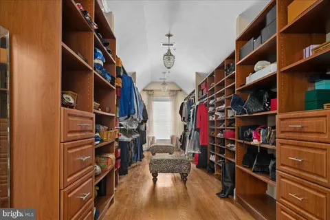 a view of walk in closet with clothes and shoes