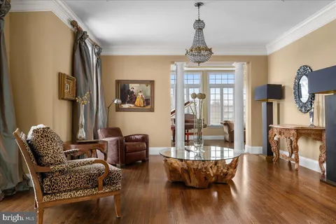 a living room with furniture two window and wooden floor