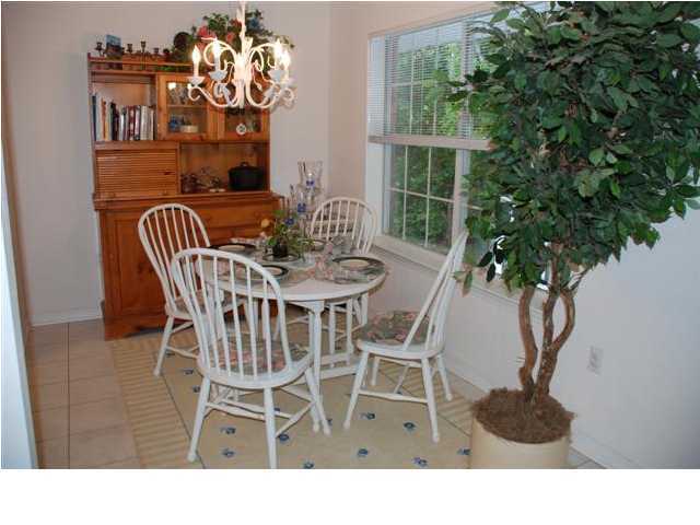 3900 Mesa Road Destin, FL 32541 - Photo 6 of 12 a black and white photo of a dining room with furniture wooden floor and a potted plant