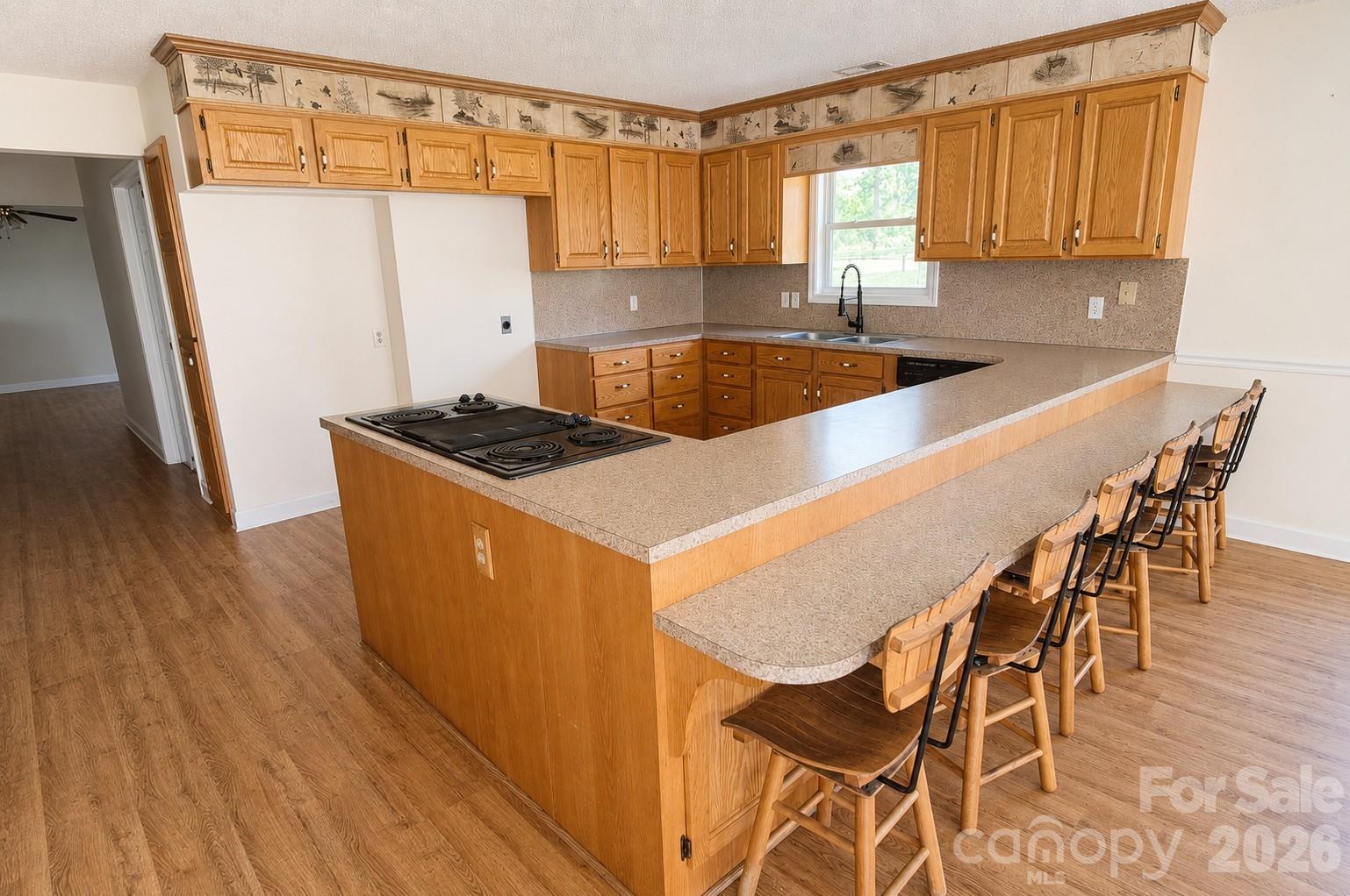 275 Noel Road Harmony, NC 28634 - Photo 6 of 10 a kitchen with granite countertop a table chairs stove and cabinets