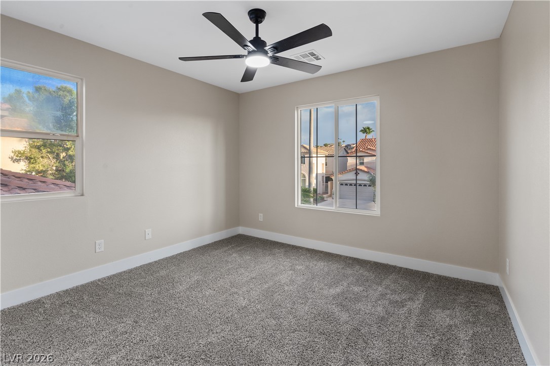 1662 Ravanusa Drive Henderson, NV 89052 - Photo 30 of 74 An airy bedroom with fresh carpet offers views of the neighborhood through well-placed windows.