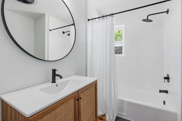 a bathroom with a sink a mirror and a bathtub