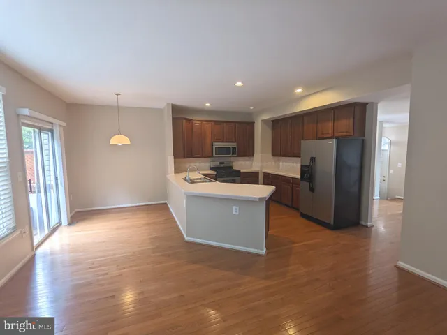a view of kitchen with refrigerator stove microwave and cabinets