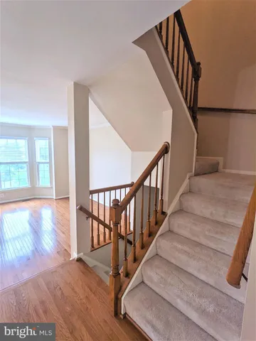 a view of staircase with railing and white walls
