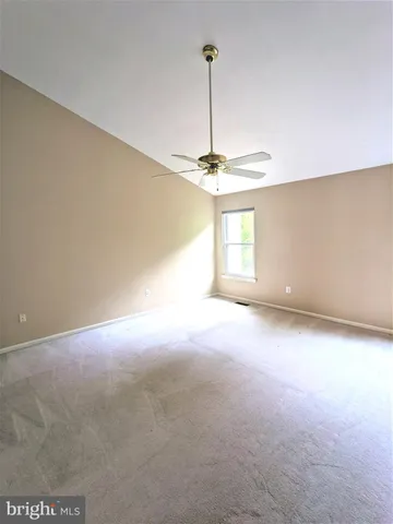 a view of a room with a chandelier fan and windows