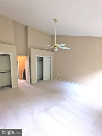 a view of a livingroom with a chandelier fan and wooden floor