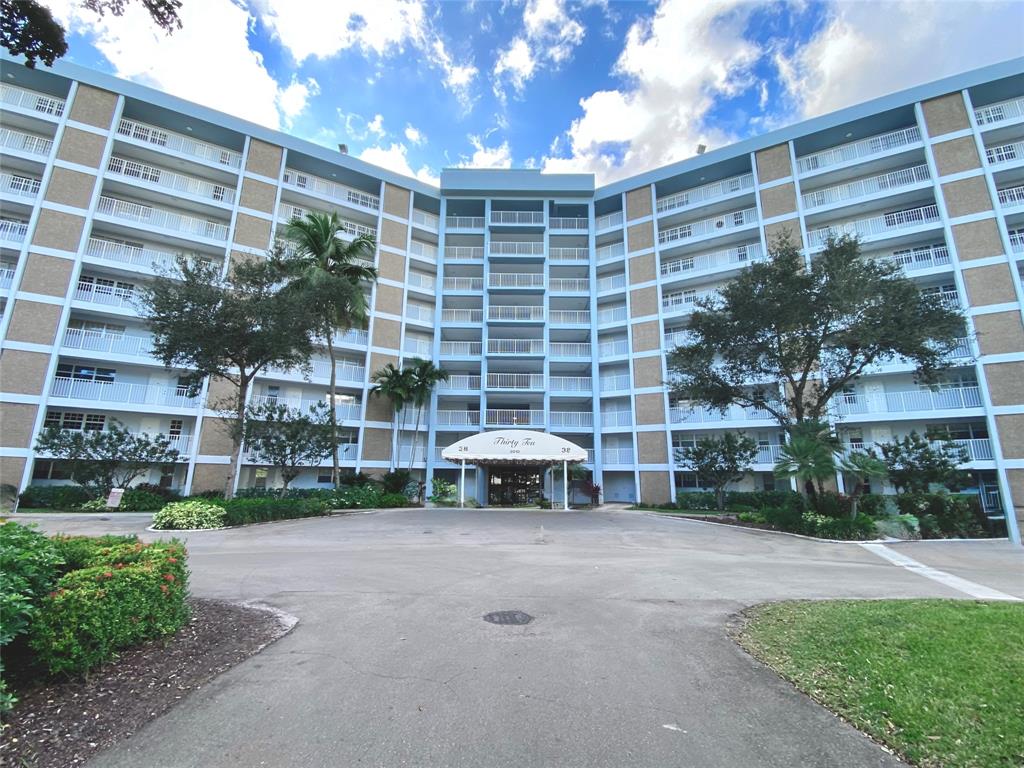 3010 North Course Drive, Unit 209 Pompano Beach, FL 33069 - Photo 27 of 39 a front view of a building with a garden