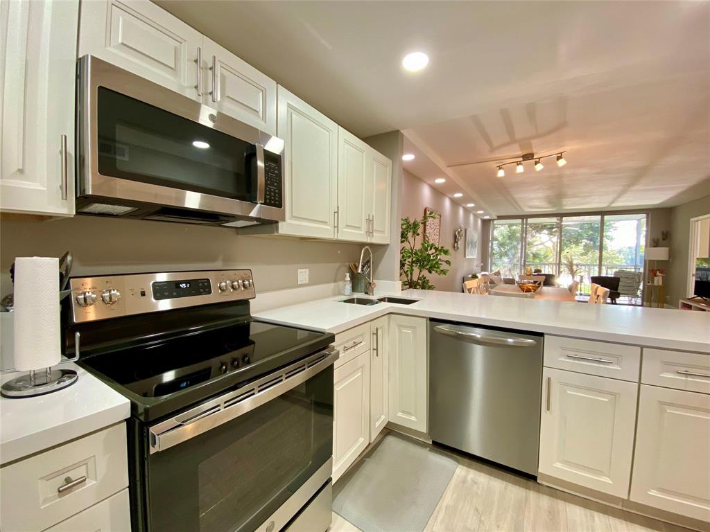 3010 North Course Drive, Unit 209 Pompano Beach, FL 33069 - Photo 6 of 39 a kitchen with a stove and a microwave