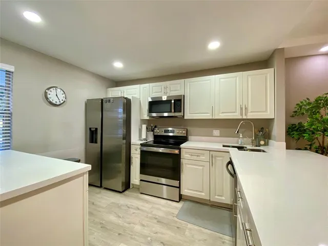 a kitchen with a refrigerator and a stove top oven