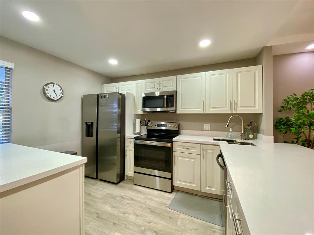 3010 North Course Drive, Unit 209 Pompano Beach, FL 33069 - Photo 7 of 39 a kitchen with a refrigerator and a stove top oven