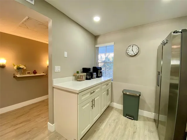 a kitchen with cabinets and wooden floor