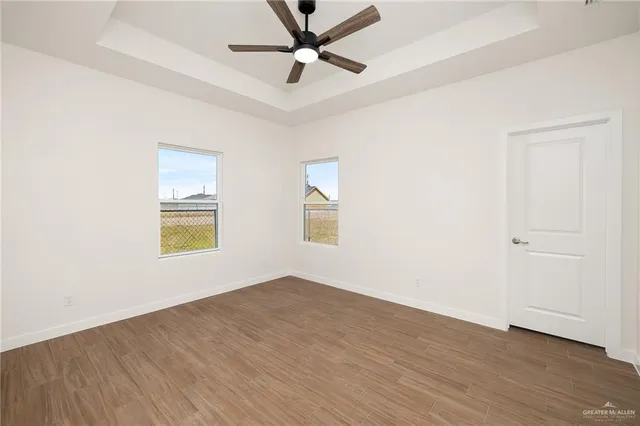 an empty room with a window and a ceiling fan