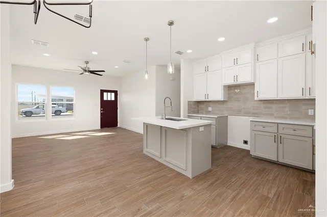 a large kitchen with cabinets wooden floor and stainless steel appliances