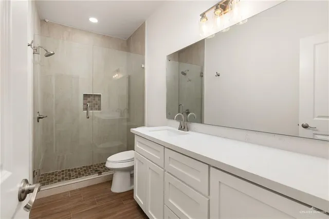 a bathroom with a sink a toilet and shower