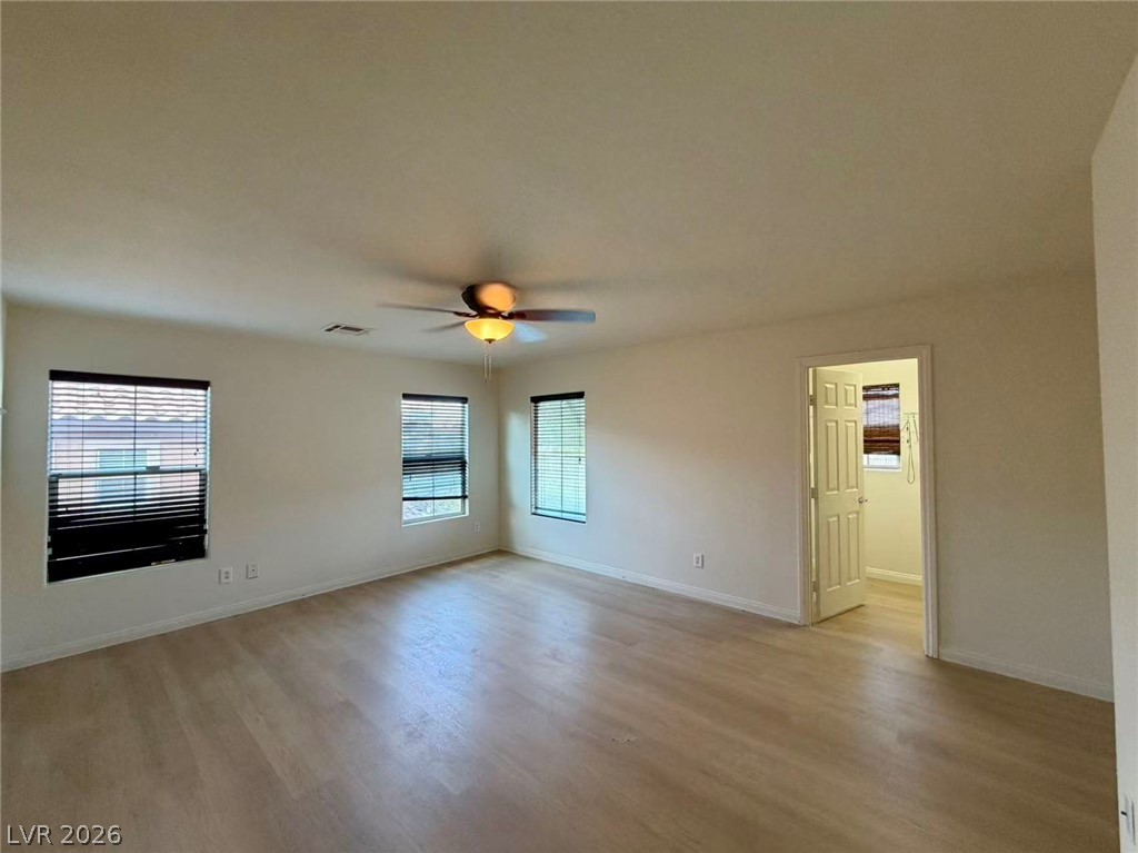 11183 Ranch Valley Street Las Vegas, NV 89179 - Photo 8 of 19 Well-lit living area featuring multiple windows and a comforting ceiling fan for year-round climate control.