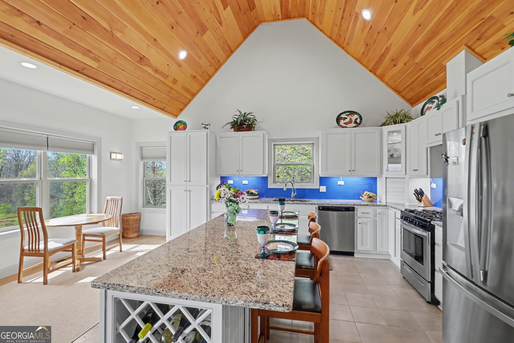 100 Deacons Way Franklin, NC 28734 - Photo 11 of 53 a kitchen with stainless steel appliances granite countertop a stove top oven a refrigerator a dining table and chairs with the outer view