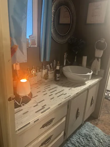 a bathroom with a granite countertop sink and a mirror