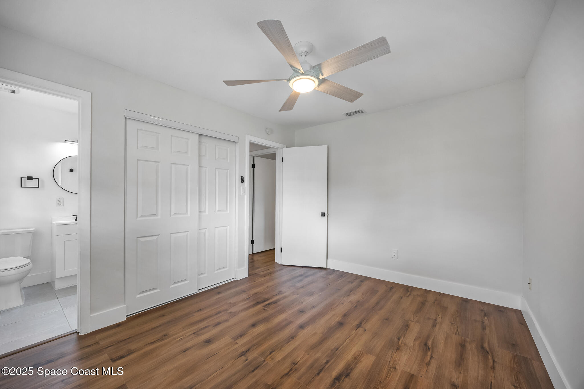 287 Edward Road Melbourne, FL 32904 - Photo 11 of 22 an empty room with wooden floor and mirror