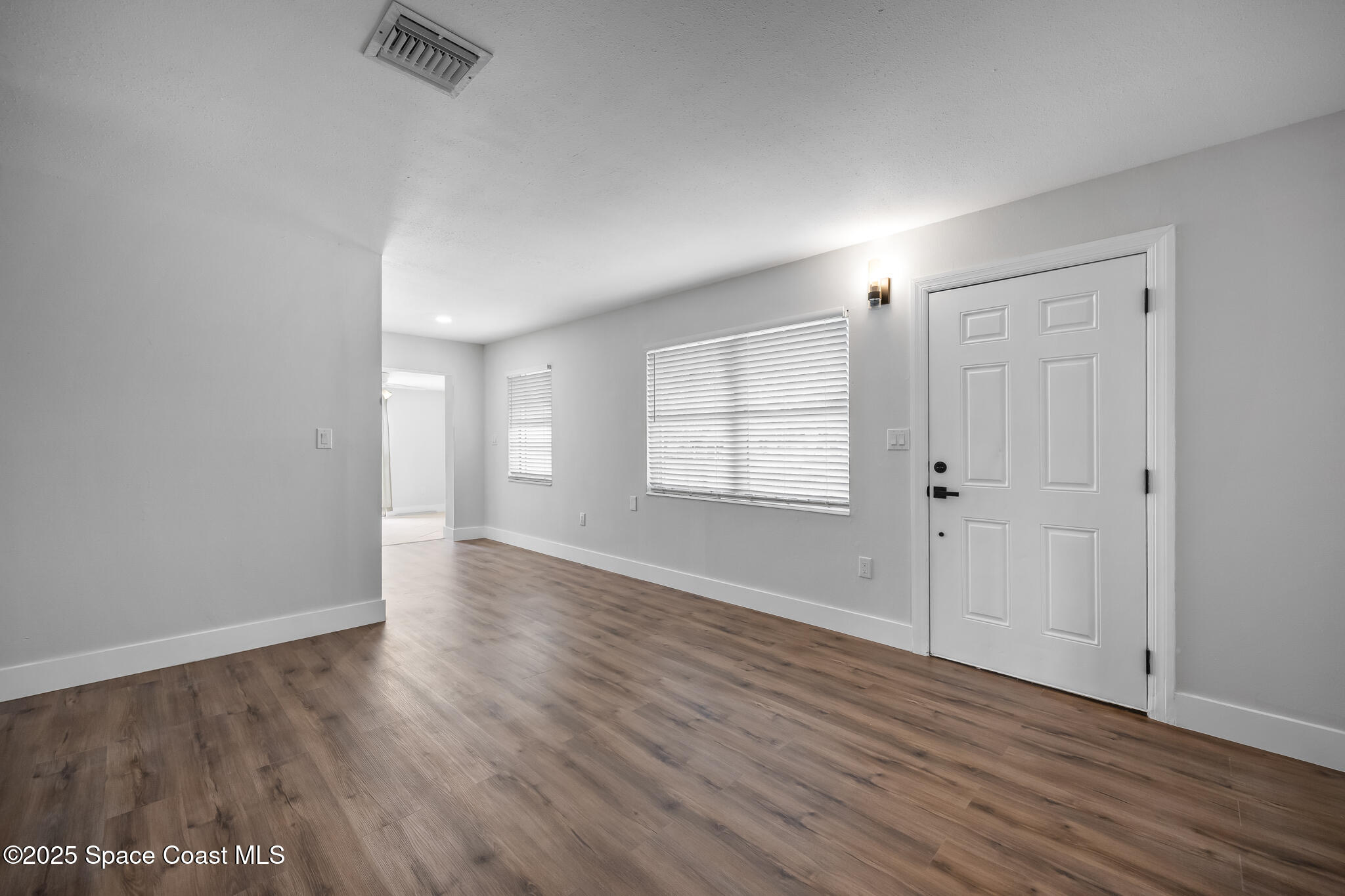287 Edward Road Melbourne, FL 32904 - Photo 4 of 22 an empty room with wooden floor and windows