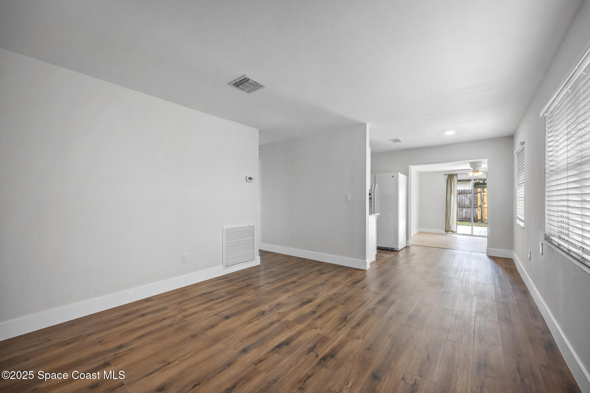 287 Edward Road Melbourne, FL 32904 - Photo 6 of 22 a view of an empty room with wooden floor and a window