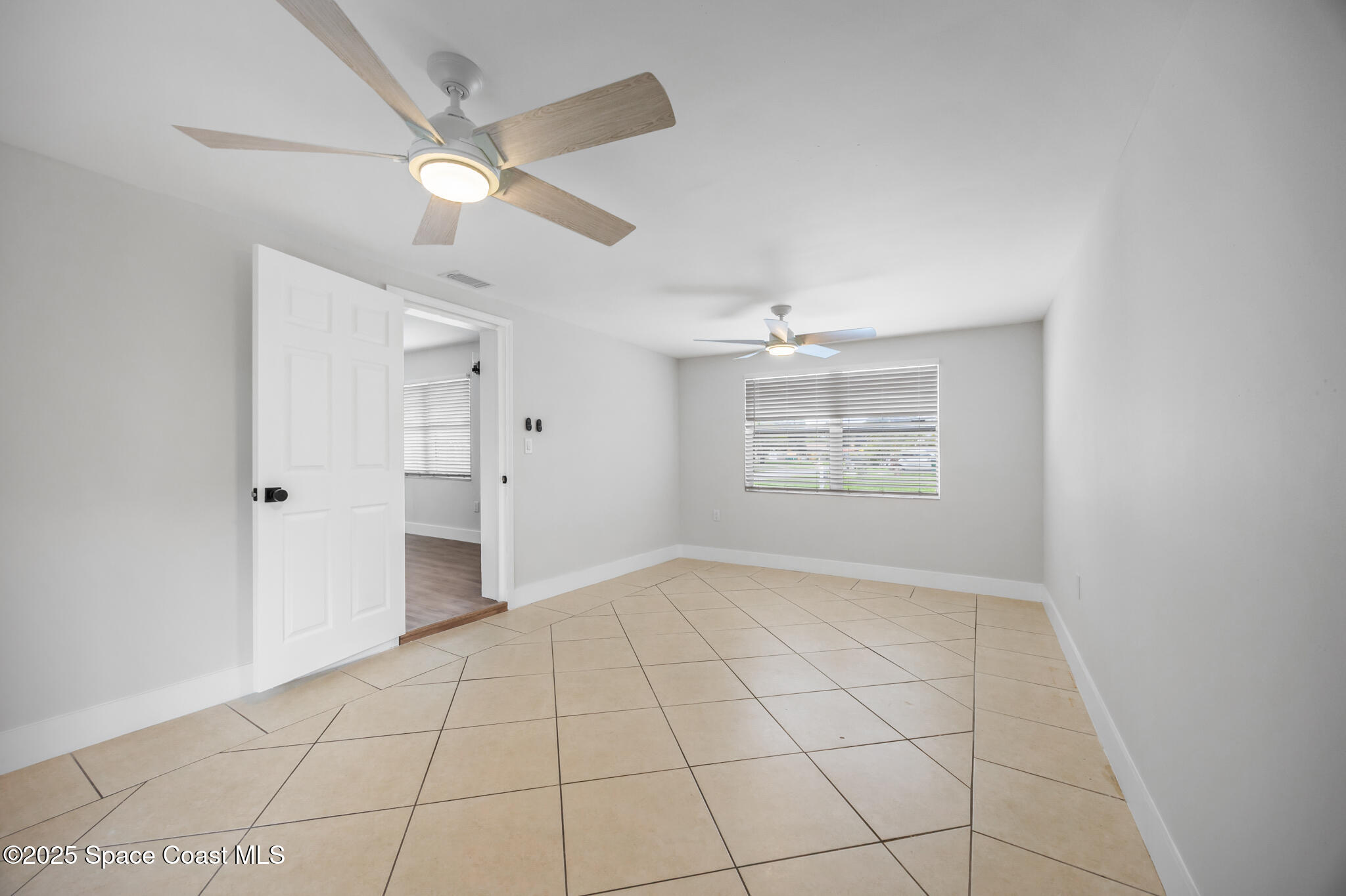 287 Edward Road Melbourne, FL 32904 - Photo 8 of 22 an empty room with white walls and ceiling fan
