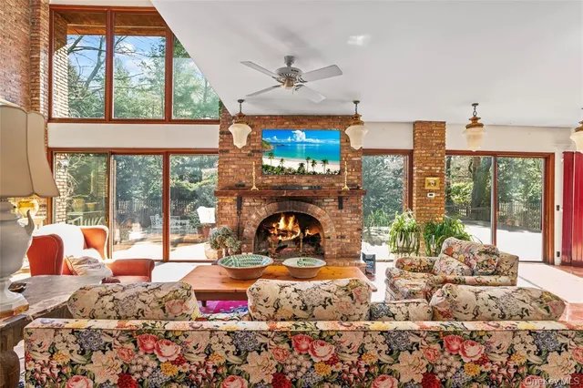 a living room with furniture fireplace and floor to ceiling windows