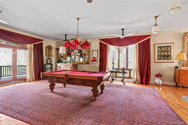 a room with pool table windows and wooden floor