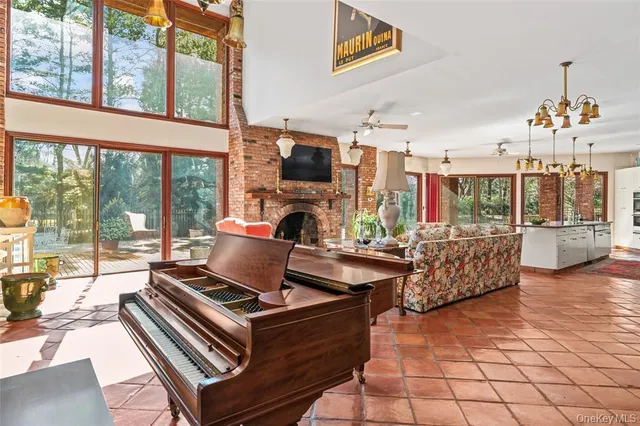 a living room with furniture a flat screen tv and a floor to ceiling window