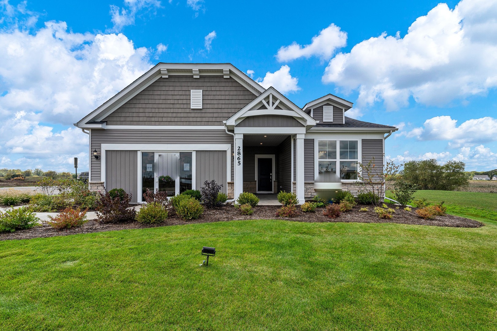a front view of a house with a yard and green space