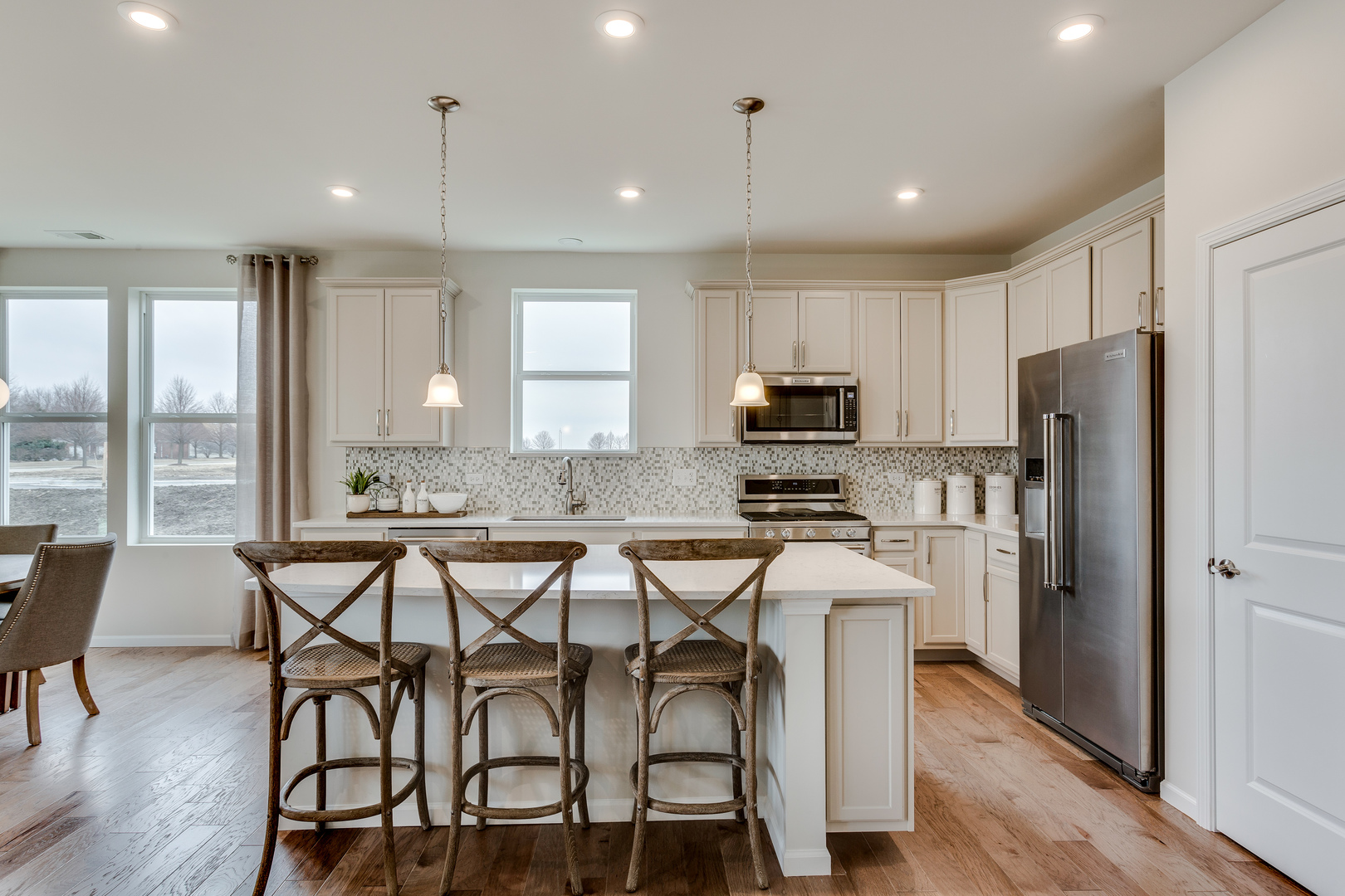 825 Spring Drive Lindenhurst, IL 60046 - Photo 5 of 29 a kitchen with granite countertop a table chairs refrigerator and microwave