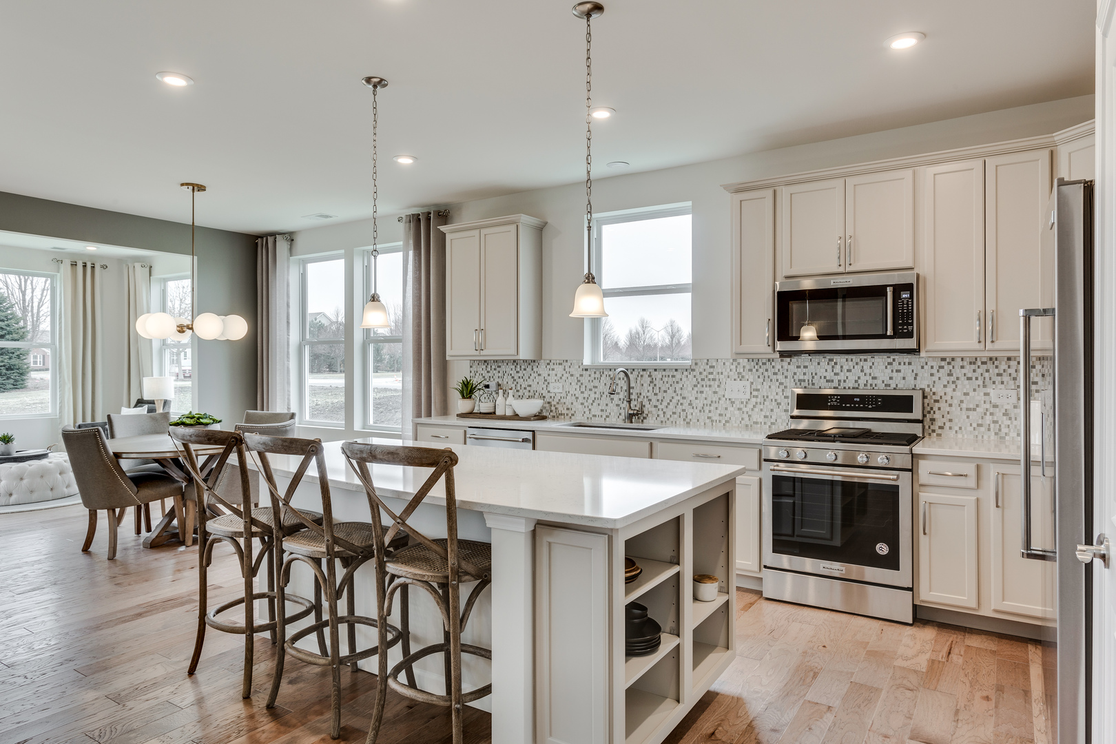 825 Spring Drive Lindenhurst, IL 60046 - Photo 6 of 29 a kitchen with stainless steel appliances granite countertop a stove a sink a microwave a island with a dining table and chairs