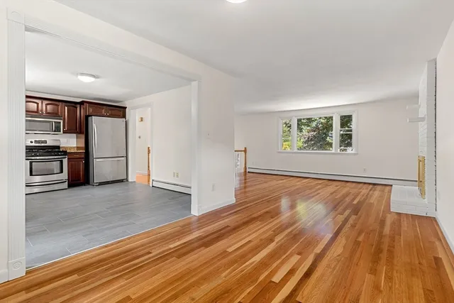 a view of empty room with wooden floor and window
