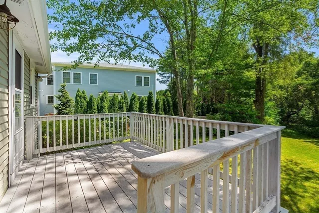 a view of a roof deck with wooden fence and trees