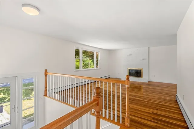 a view of a bedroom with wooden floor and windows