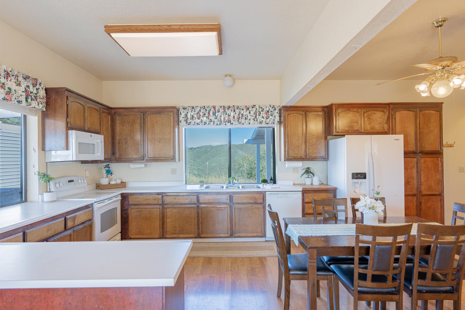 5912 Old Gulch Road San Andreas, CA 95249 - Photo 2 of 71 a kitchen with stainless steel appliances a table chairs sink refrigerator and cabinets